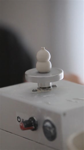 Throwing a tiny vase on a miniature pottery wheel