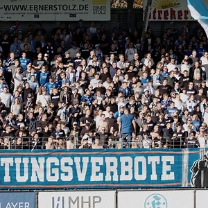 Feiere 125 Jahre Stuttgarter Kickers mit der exklusiven Jubiläumsbox! Sichere dir das limitierte Set mit Retro-Trikot und edlem Schal, inspiriert von der Gründerzeit. Das dunkelblau-weiß gestreifte Trikot mit goldener Kickers-3D-Logo-Applikation und einzigartigen Details wie „Kämpfer - Könner - Kameraden“ wird ergänzt durch einen hochwertigen Schal mit gesticktem Traditionslogo. Verpackt in einer stilvollen Magnetbox mit historischen Bildern – ein Must-have für jeden Fan! | Stuttgarter Kickers
