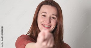 Woman beckon with finger, portrait, close-up. Female with braces teeth looks at camera and beckons to herself with her index finger Generative AI