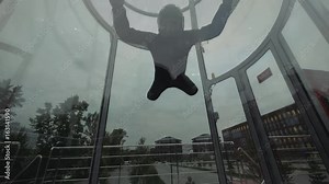 Man skydiver fly into wind tunnel up and down. Flying in a skydiving tunnel