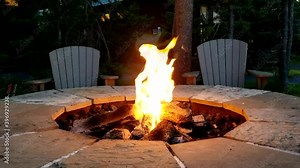 Dancing flames in stone firepit outdoors at night time