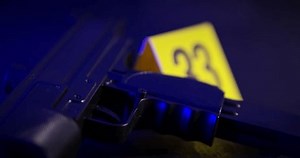 A gun is tagged as police evidence at a crime scene.