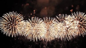 4K. loop seamless of real fireworks background. abstract blur of real golden shining fireworks with bokeh lights in the night sky. glowing fireworks show. New year's eve fireworks celebration