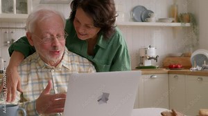 Delighted seniors embracing technology. Elderly couple socializing on laptop. Happy older couple using laptop and exploring the internet together. grandparents having fun online