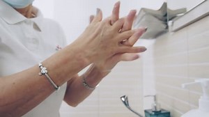 Female lab worker washes her hands before taking blood. Woman washing her hands with soap