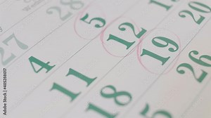 Person marking important dates on the calendar with a red pencil. Planning important business meetings and events. Close up 4k footage.