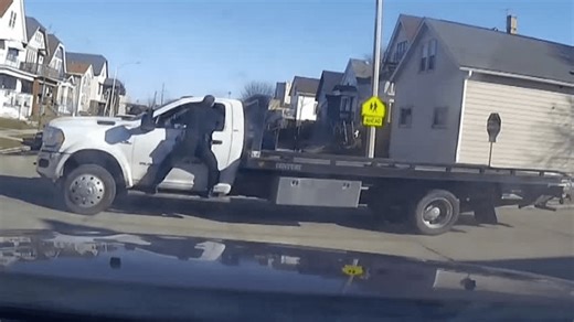 VIDEO: Tow truck driver speeds away as officer hangs off side of truck, shoots driver