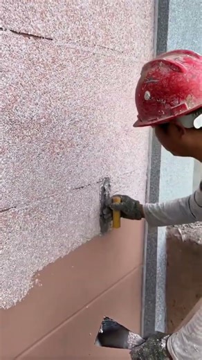 the process of plastering colored sand powder on the walls on the outside of a building #popular