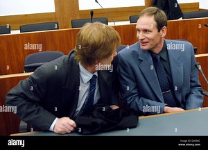 (dpa) - 42-year-old German computer specialist Armin Meiwes (R) chats with his lawyer Harald Ermel during the second day of his trial at the district court in Kassel, Germany, 8 December 2003. The court was set to view video tapes showing how the self-declared cannibal killed, cut up and ate his victim. The second day of the murder trial of Meiwes began with evidence to be given by Stock Photo - Alamy