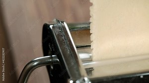 Chef use pasta cutting machine. Traditional italian homemade pasta being made on pasta machine.