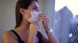 clip-1057563718-young-woman-putting-covid-mask-prevention-attractive