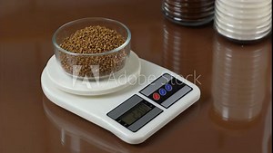 Buckwheat on kitchen scales․ Products are weighed on kitchen scales. Healthy eating concept. Diet and calories counting concept. Unroasted buckwheat grains. breakfast time. Diets products.