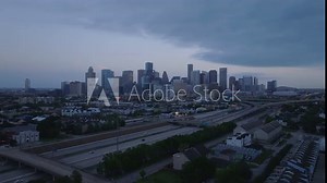 Houston skyline at dusk from above, highlighting the city's mix of modern downtown buildings and highways with traffic coming to town