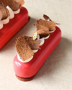 This stunning cake has a vanilla mousse, crunchy chocolate cremeux, cherries and a bright red mirror glaze. I used a small paintbrush to create the chocolate 'leaves' and dusted them with cocoa powder to finish! | Matt Adlard