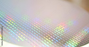 A close-up view of a silicon wafer's microprocessor circuit layout. The semiconductors or central processing unit CPU microchips are fabricated from a silicon wafer with patterned layers of materials.