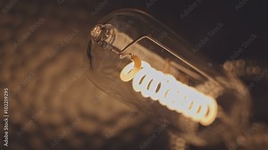 Filament of electric bulb. Real light bulb flickering. Incandescence thread, close up. RAW video record.