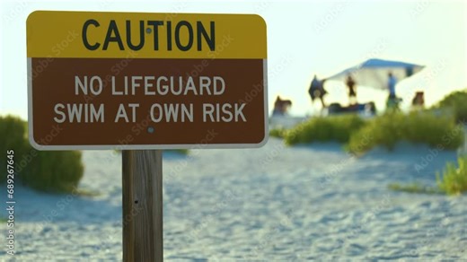 Warning sign poster on sea side beach saying that there is no lifeguard on duty