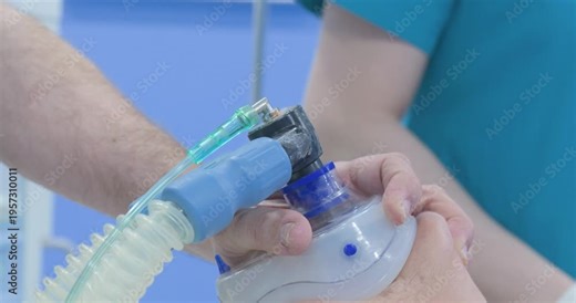 Close-up of medical professional applying an oxygen anesthesia mask to a patient before surgery in an operating room.