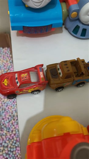 yellow bus pushing red mcqueen and brown tow mater in pit, pixar cars