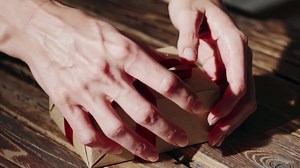 Download Unwrapping a Gift Scene with Delicate Hands and Ribbon for free