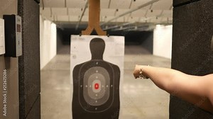 Woman uses a motorized slider to move a target closer at a indoor firing range Stock Video
