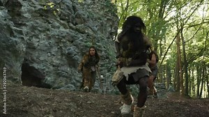 Primitive wild family of neanderthals hunting in the forest. African nomadic tribe of hunter-gatherers chasing mammoth for animal prey. Paleolithic people.