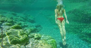 Woman, swimming and underwater for island adventure or Italy explore as holiday, tropical or summer. Female person, bikini and outdoor travel or stroke in European lake or paradise, ocean or vacation