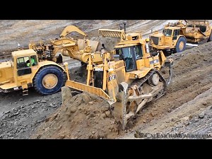 Cutting through hills with CAT 657 Scrapers to build a new roadway