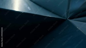 A series of dark, reflective planes intersecting at sharp angles, illuminated by bounce light.