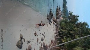 Tropical beach loving couple embraces surrounded by romance of tropical nature aerial view. Romance of moment highlights their love and promise of shared future. Perfect romance happy family life.