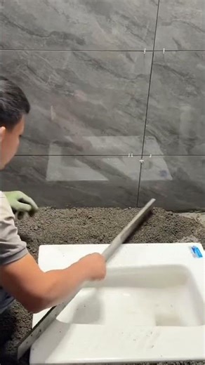the process of spreading cement in the area around the toilet when installing ceramic tiles