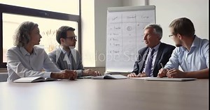Senior business leader, executive man meeting with team in boardroom, talking to employees, discussing supply package, speaking with hands gestures, explaining work plan, giving instruction, task