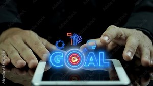 Goals achievement business, strategy, purposefulness, planning development concept. Businessman using tablet to show animation of GOAL icon with arrow hits the center of the target.