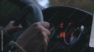 Female hands driver on steering wheel, woman driving the car by road at night , slow motion.