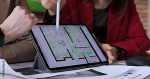 Interior designers using tablet for design, focusing on floor plan details Integrating traditional drafting with digital tools for innovative solutions. Collaborative work office, boosting creativity