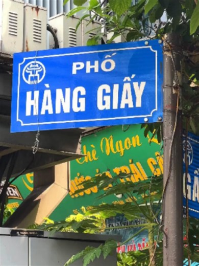 🏘️ DẤU TÍCH PHỐ NGHỀ: PHỐ HÀNG GIẤY 📜 Một con phố mang tên “Giấy”, nhưng phía sau cái tên ấy là câu chuyện về cả nghề xưa và những năm tháng Hà Ni rực lửa. Phố Hàng Giấy nằm trong khu phố cổ Hà Nội, nối từ khu vực Hàng Đậu đến chợ Đồng Xuân, với một nét rất riêng: đường sắt chạy ngang qua phố. Thuở trước, Hàng Giấy từng là nơi tập trung buôn bán nhiều loại giấy của đất Kẻ Chợ: giấy dó, giấy sắc, giấy moi, giấy bổi… Tên phố cũng từ đó mà thành, lưu lại dấu vết của một phố nghề giữa Thăng Long –