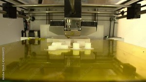 3d printer head at work, printing small details with white filament,