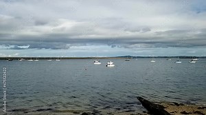 Slowly panning across Holyhead harbour waterfront to Irish ferries port still seascape and breakwater horizon