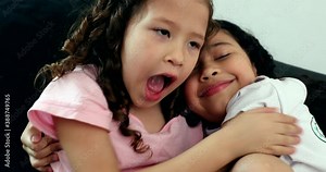 Children hugging each other, two little sisters hug in affection and love