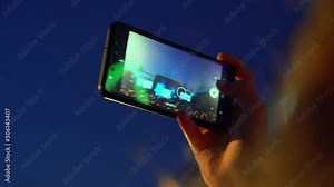 Happy people are watching an amazing musical concert. Merry fans jump and raise their hands up. Fans are filming a concert on a smartphone. Live concert.