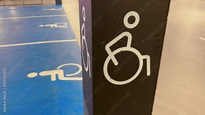 A pillar with disabled sign at underground mall parking lot against blue sign Stock Video