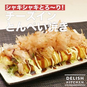 たっぷりキャベツをくるっと巻いて、とん平焼きに！ 中から溢れる、とろけるチーズが最高です！ ボリューム満点！今晩の1品におすすめです♪ ■材料 (2人分) ・豚バラ薄切り肉 80g ・卵 2個 ・キャベツ 4枚 ・ピザ用チーズ 100g ・サラダ油 大さじ２ ・塩こしょう 適量 ・お好み焼きソース 適量 ・マヨネーズ 適量 ・かつお節 適量 ■手順 1. キャベツは千切りにする。豚肉は一口大に切る。 2. ボウルに卵を割り入れ、よく混ぜる 3. フライパンに半量のサラダ油を入れて熱し、豚肉を入れて、肉の色が変わるまで中火で炒め、塩こしょうをふり、取り出す 4. 残りのサラダ油を入れて熱し、2を流し入れて、表面が半熟になったら、ピザ用チーズ半量、豚肉、キャベツ、残りのピザ用チーズをのせる 5. 卵に火が通ったら手前から巻く。巻き終わりが下になるようにしたらふたをして、弱火で2分ほど焼く 6. 器に盛り付け、お好み焼きソース、マヨネーズ、かつお節をふりかける アプリ・WEBでこのレシピをもっと詳しくチェック！ delishkitchen.tv/recipes/164441030945407