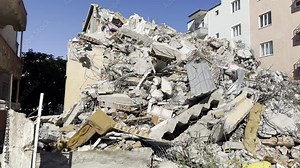 A building destroyed in the earthquake and other buildings that remained intact next to it