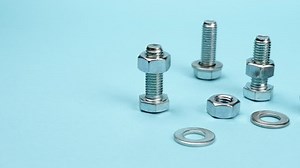 Bolts, nuts and washers for fastening on a blue background. Panorama. Tool accessories mechanics.
