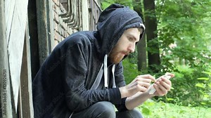 Man feels nervous while texting message to his dealer on smartphone
