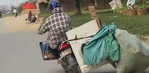 Woman tests limits of physics by carrying washing machine on bike