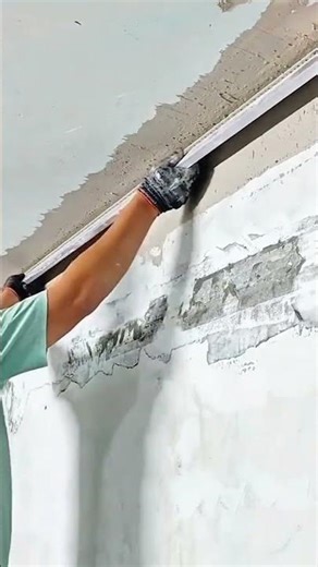 Skilled worker smoothing ceiling joint compound for perfect seamless finish
