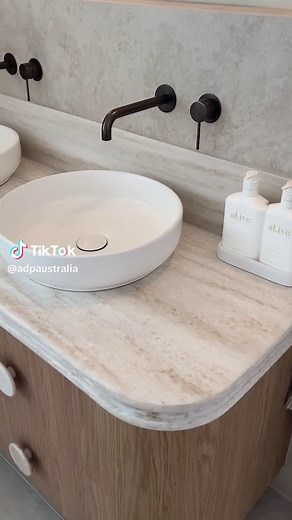 This bathroom is all about the curves 😍 Our Royale benchtop elevates the Thea vanity without overpowering the space. Featured here in Boston Oak with a curved Royale benchtop in Sakal, paired with matching Vale handles. Featured project by @georgiabreenevill All products and video by @yeomansbc