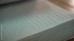 Turning the pages of a large book for blind people with text written in braille