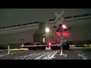Railroad Crossing during Nighttime Snowfall